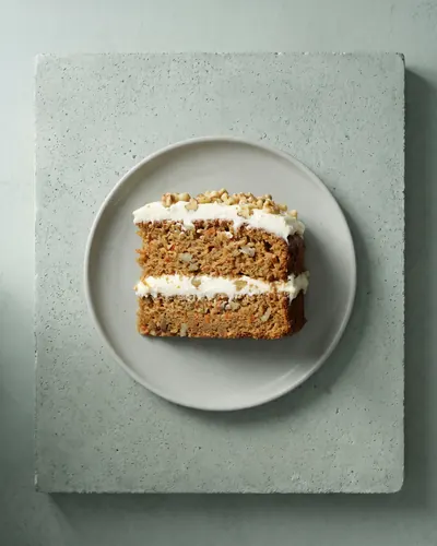 Porción de tarta de zanahoria con crema de queso, vista desde arriba sobre hormigón (imagen generada con IA)